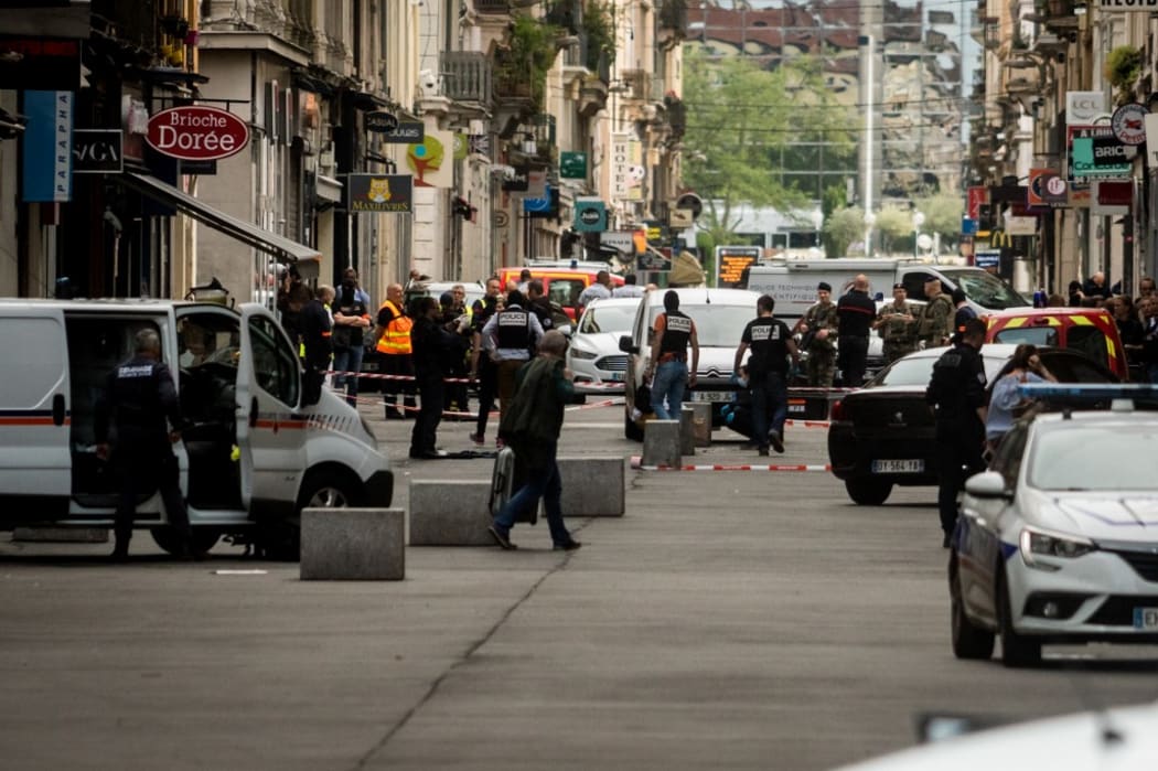 French police search for evidence after a suspected package bomb blast along a pedestrian street in the heart of Lyon, southeast France.