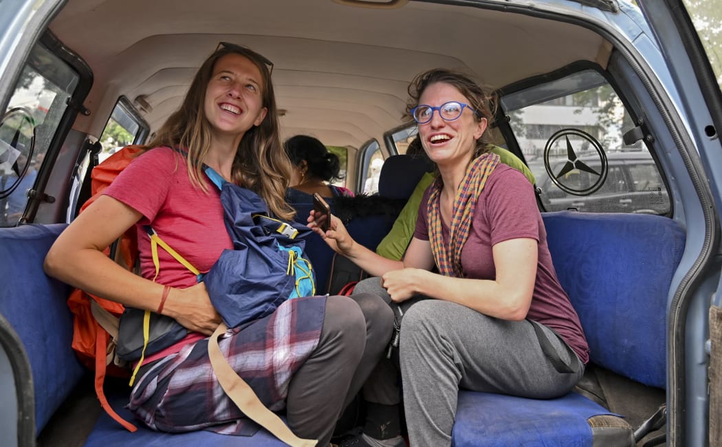 Tourists from Belgium look on as they sit inside a car to leave Kashmir in Srinagar on August 3, 2019.
