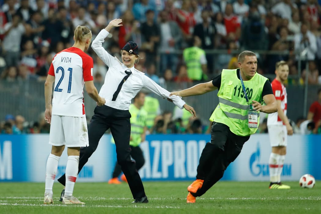 Stewards remove pitch invaders during the Russia 2018 World Cup final football match between France and Croatia at the Luzhniki Stadium in Moscow on July 15, 2018