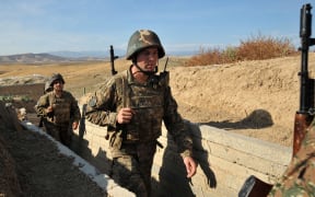 A file photo taken in October 2012 shows Armenian soldiers of Nagorno-Karabakh walking in trenches at the frontline on the border with Azerbaijan.