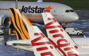 Jetstar, Tiger and Virgin planes sit idle on the tarmac at Melbourne's Tullamarine Airport on 12 April 2020.