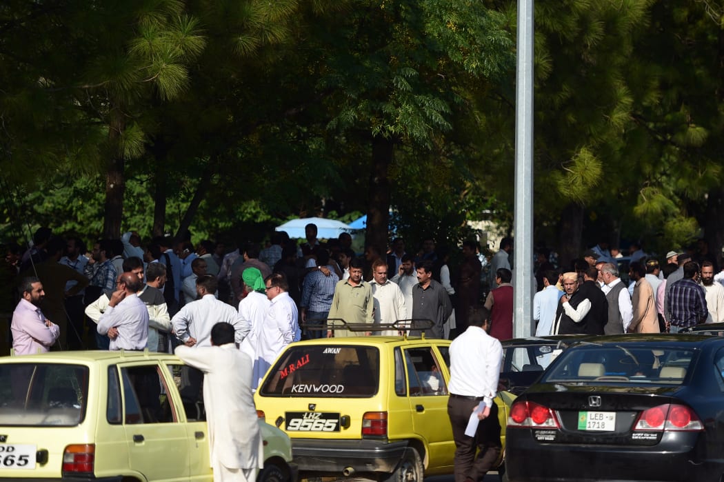 Pakistani federal employees gather outside their offices after a 7.5-magnitude quake in neighbouring Afghanistan shook Islamabad on October 26, 2015.