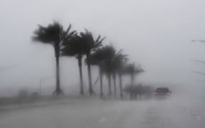 Commuters make their way through heavy rain in Jacksonville, Florida, on October 6, 2016, ahead of hurricane Matthew.