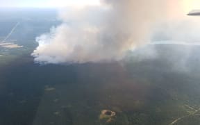 A wildfire seen burning near the town of 100 Mile House.