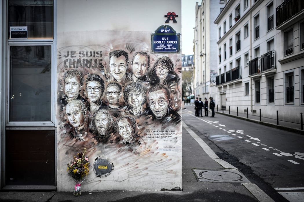 File photo taken on January 7, 2019 shows police officers next to a painting by French street artist and painter Christian Guemy, known as C215, in tribute to members of Charlie Hebdo newspaper who were killed in January 2015.