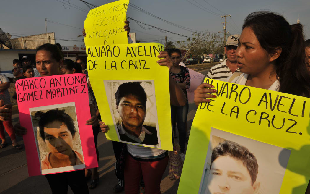 Residents of the Allende community march holding banners with images of missing workers of the state-run oil giant Pemex's Pajaritos petrochemical plant, in Coatzacoalcos, Veracruz State, Mexico.