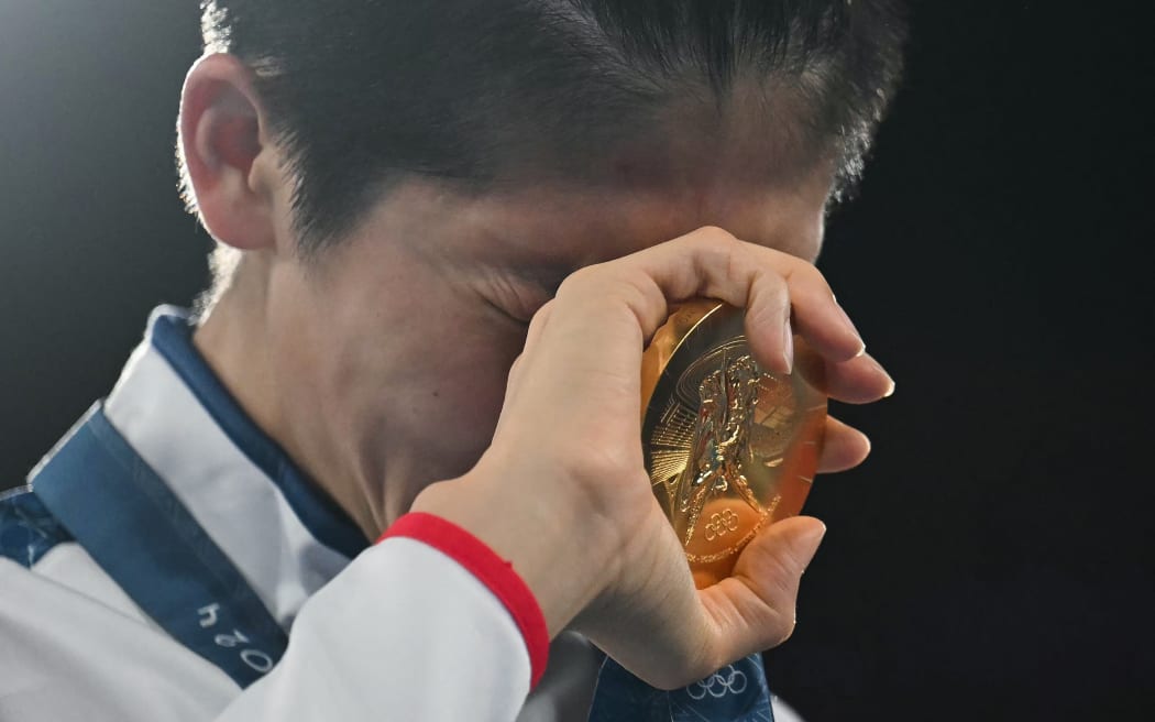 Gold medallist Taiwan's Lin Yu-ting celebrates on the podium during the medal ceremony for the women's 57kg final boxing category. Paris 2024 Olympic Games.