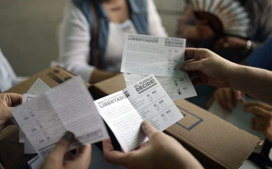 Volunteers count the ballots during an opposition-organized vote to measure public support for Venezuelan President Nicolas Maduro's plan to rewrite the constitution.