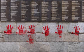 Red hands graffitis are seen on the "Wall of the Righteous" (Mur des Justes) outside the Shoah memorial in Paris, on May 14, 2024, after the monument was vandalized overnight with the president of the Representative Council of French Jewish Institutions (CRIF) denouncing the act as antisemitic. (Photo by Antonin UTZ / AFP)