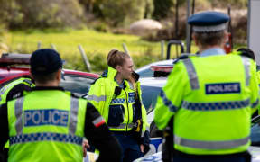Police gather near the intersection of SH1 and Mill Rd, Bombay, prior to setting up a Covid-19 roadblock.