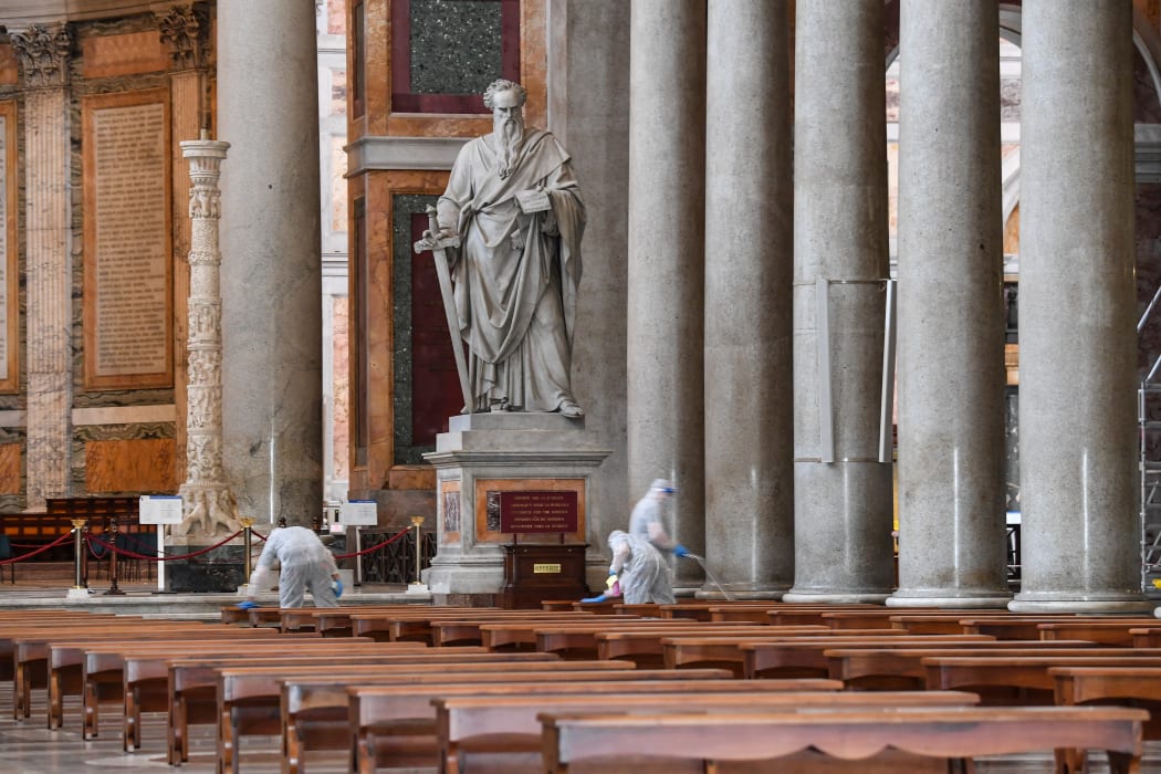 Men clean the floor and surfaces of the churchyard of the Basilica of Saint Paul Outside The Walls in Rome, on 16 May.