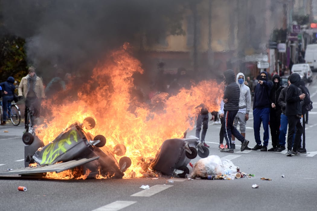 People watch a fire on the Pont Neuf, in Toulouse, southern France as part of the fourth day of mobilization of high school students in the wake of the movement of "yellow vests".