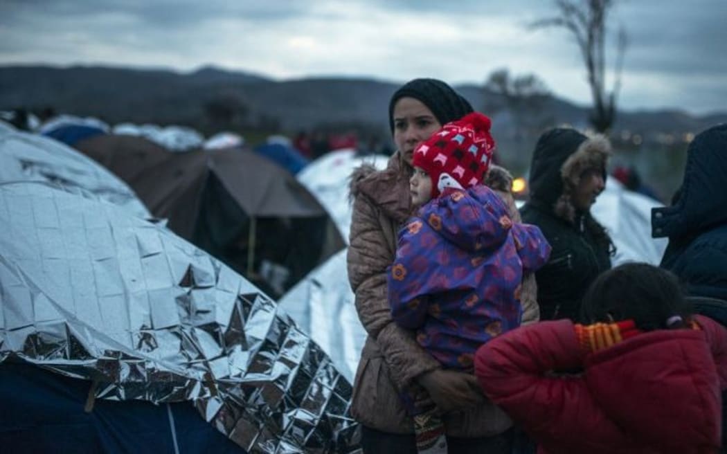 A woman waits for permission to cross the border into Serbia at a makeshift camp near the village of Tabanovce.