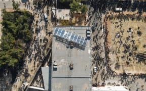 People gather at the Sednaya prison as Syrian rescuers search for potential hidden basements at the facility in Damascus on 9 December, 2024.