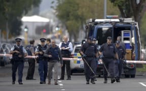 Police officers search the area near the Masjid Al Noor mosque, site of one of the mass shootings at two mosques in Christchurch, New Zealand, Saturday, March 16, 2019. (AP Photo/Mark Baker)