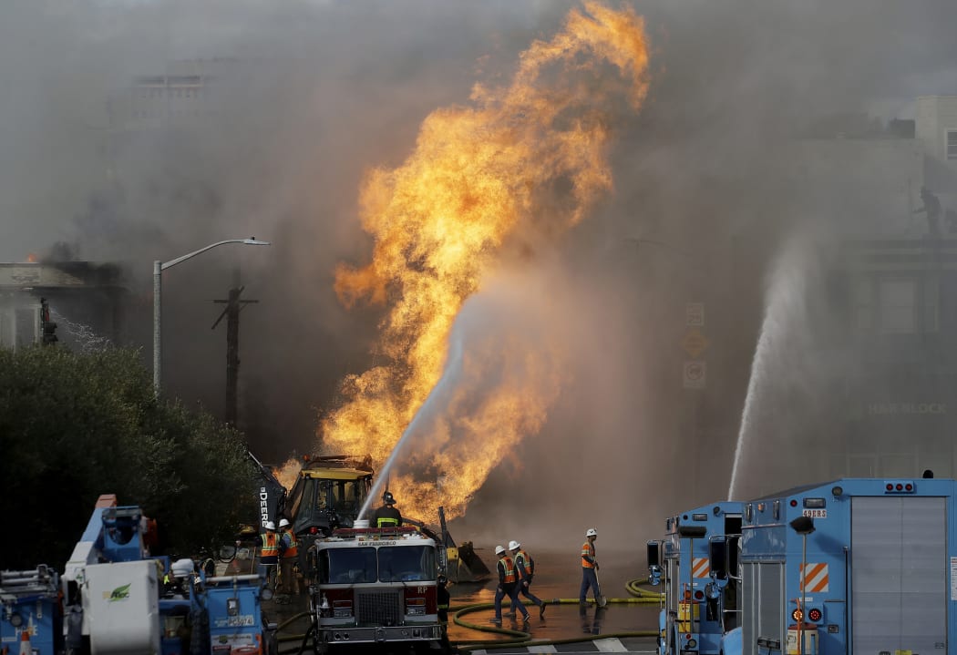 Pacific Gas and Electric workers work as San Francisco firerighters battle a fire in San Francisco, Wednesday, Feb. 6, 2019.