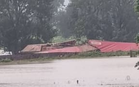 Flood waters surround the derailed train in Te Puke.