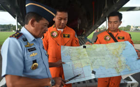 Western Indonesia Air Force operation commander Air Vice Marshal Agus Dwi Putranto (left) briefs crews before the search.