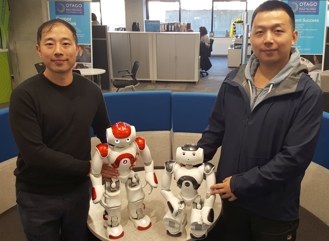 Alix Chen and Kai Feng with two Nao robots.