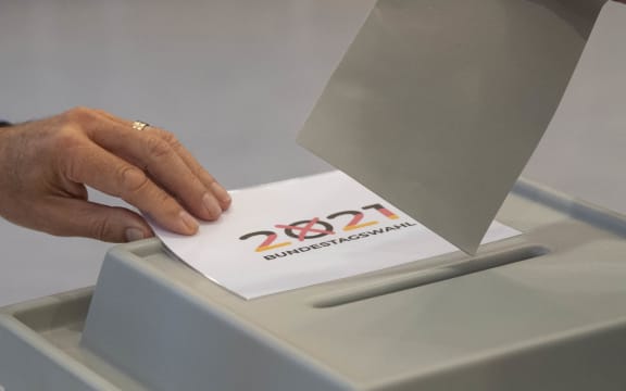 A voter casts his ballot papers for the German federal elections at a polling station in Gutach near Freiburg in the Black Forest region, southern Germany