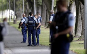 Police keep watch at a park across the road from a a mosque in central Christchurch, New Zealand