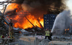 Firefighters douse a blaze at the scene of an explosion in Beirut's port district.