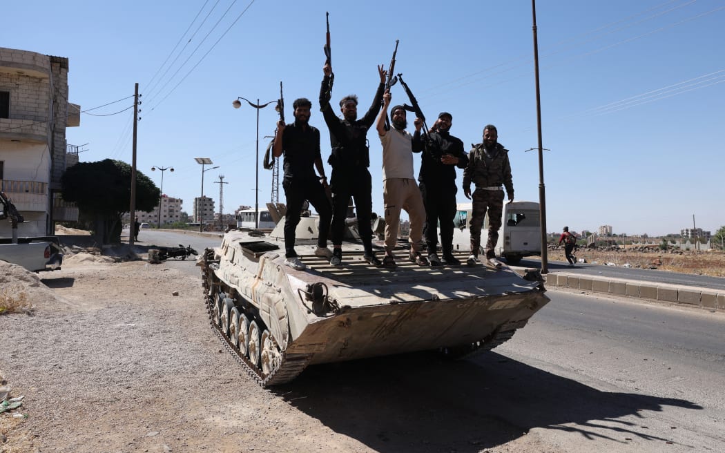 Syria's security forces stand on a tank in the predominantly Druze city of Sweida on July 15, 2025, following clashes between Bedouin tribes and Druze fighters. Syrian government forces entered the majority Druze city of Sweida on July 15, 2025, the interior ministry said, aiming to end clashes with Bedouin tribes that have killed nearly 100 people. (Photo by Bakr ALkasem / AFP)