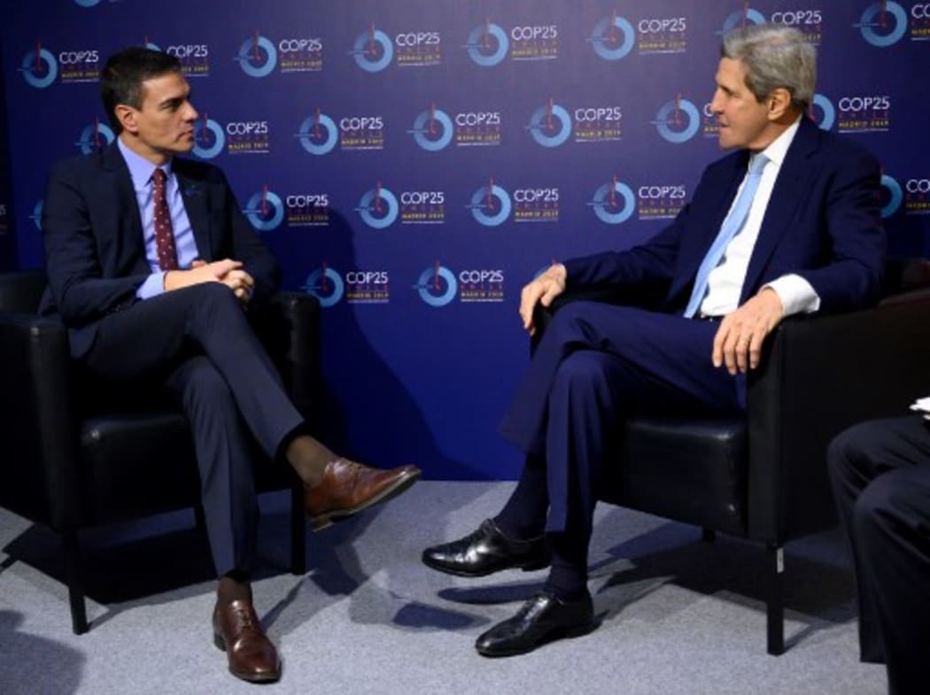 Spanish Prime Minister Pedro Sanchez (L) meets with former US secretary of state John Kerry during the UN Climate Change Conference COP25.