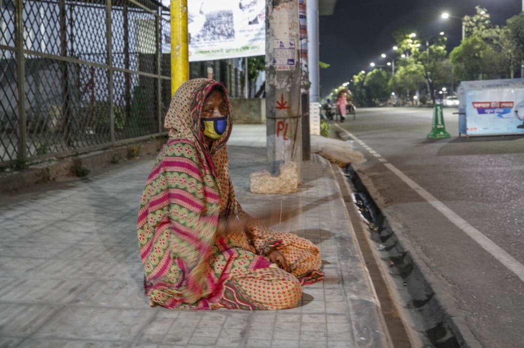 People waiting by the side of the street for relief in Dhaka, Bangladesh. Covid-19 lockdowns mean many poorer people are starving.