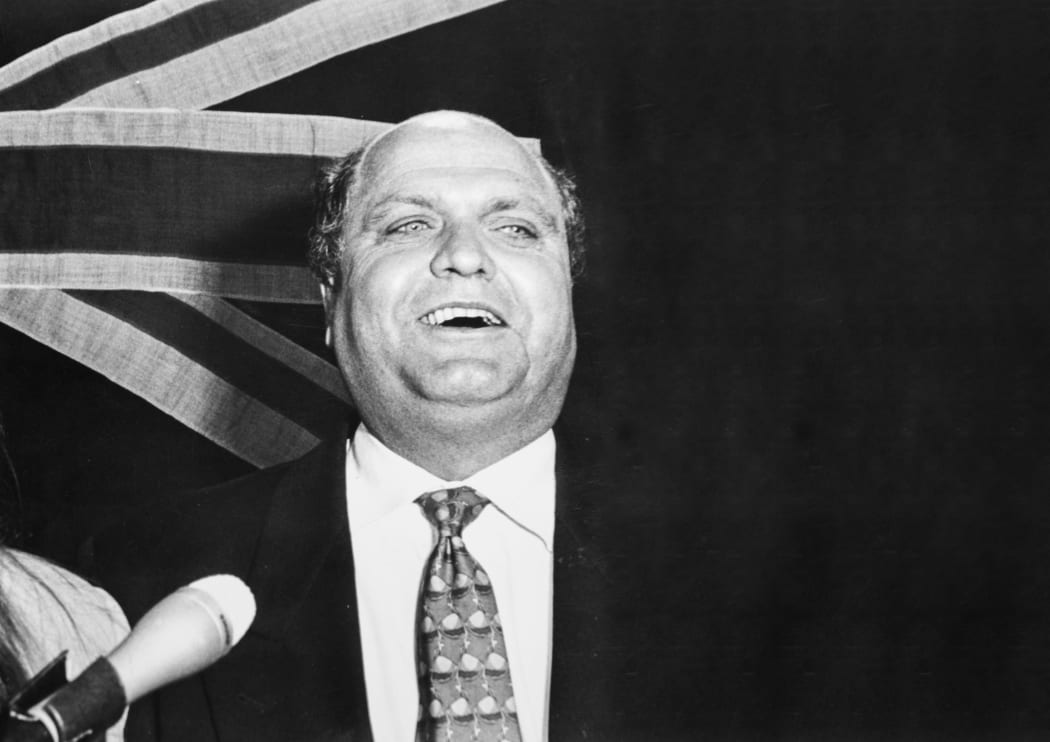 Mike Moore in front of flag, 1993
