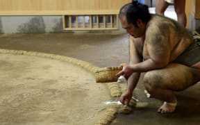 Salt is thrown into the sumo ring before a match to purify it. File photo.