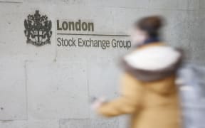 (FILES) A pedestrian walks past the logo for the London Stock Exchange Group outside the stock exchange in London on December 29, 2020. The Metropolitan Police reported Sunday, January 14, that detectives had arrested six activists from the Palestine Action group who were intending to target the London Stock Exchange on Monday morning (15th), with the intention of preventing the building from opening for trading. (Photo by Tolga Akmen / AFP)
