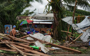 A resident looks at a house damaged at the height of Typhoon Phanfone in Tacloban, Leyte province in the central Philippines on December 25, 2019.