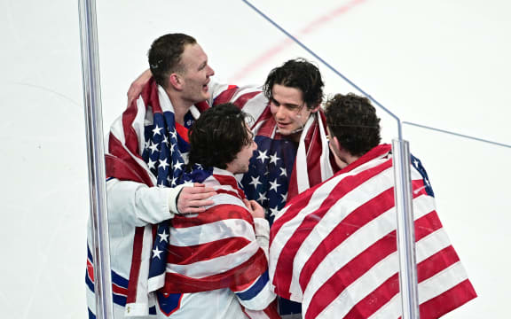 USA's Jack Hughes (C) celebrates with  teammates after winning  the men's gold medal ice hockey match against Canada, Winter Olympics, 2026.