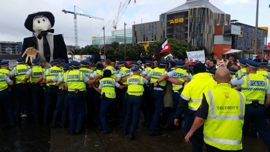 Police and protesters clash outside the annual defence forum in Auckland