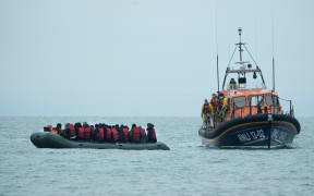 Migrants are helped by RNLI (Royal National Lifeboat Institution) lifeboat before being taken to a beach in Dungeness, on the south-east coast of England, on November 24, 2021, after crossing the English Channel.