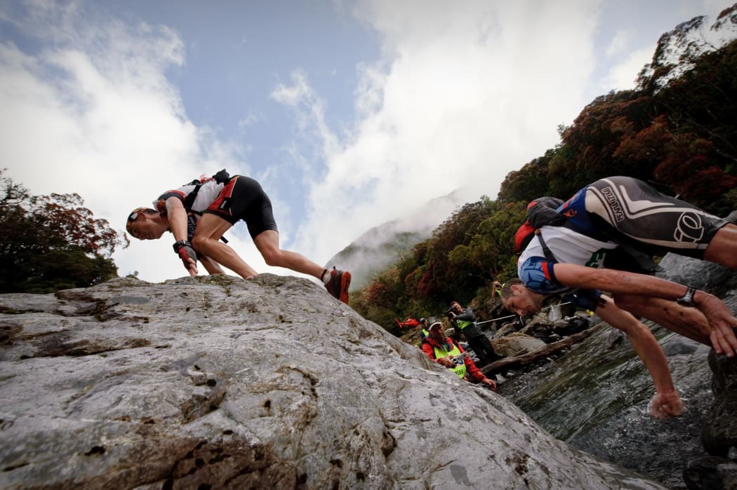 Competitors climb over large boulders in the Mingha Deception Route on the way to Goat Pass during the first day of the Coast to Coast in 2010.