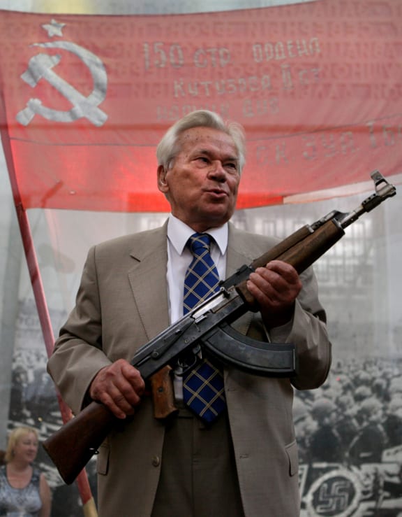 Mikhail Kalashnikov poses with the first model of his AK-47 assault rifle at a ceremony celebrating the 60th anniversary of the weapon.