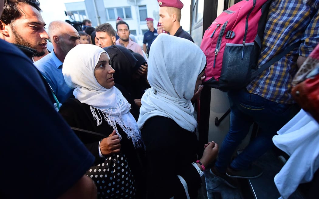 Migrants are escorted by police from Bicske train station to a bus that will take them into a refugee camp.