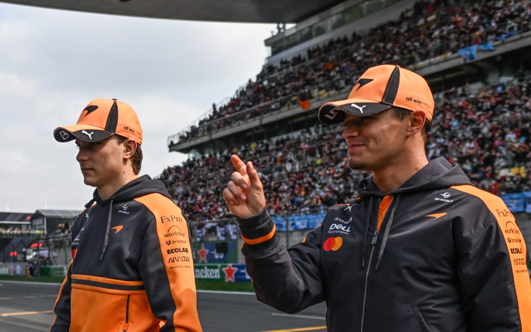 Lando Norris (R) and Oscar Piastri of McLaren walk off after the drivers' parade ahead of the Chinese Grand Prix in Shanghai. Both drivers didn't take part in the race.   (Photo by Artur Widak/NurPhoto) (Photo by Artur Widak / NurPhoto via AFP)
