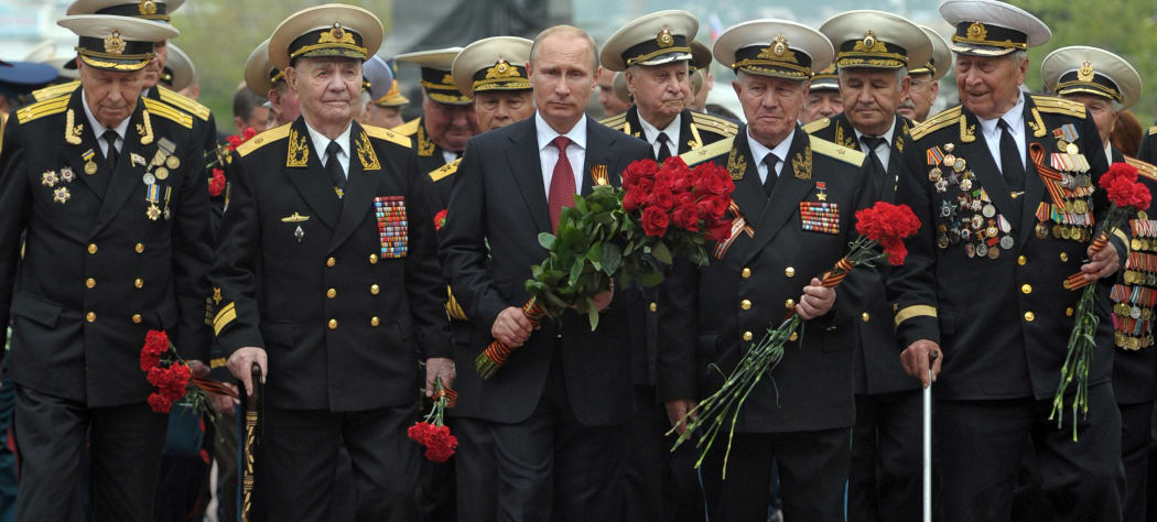 Russia's President Vladimir Putin (centre) and World War II veterans lay flowers at a war memorial in Sevastopol.
