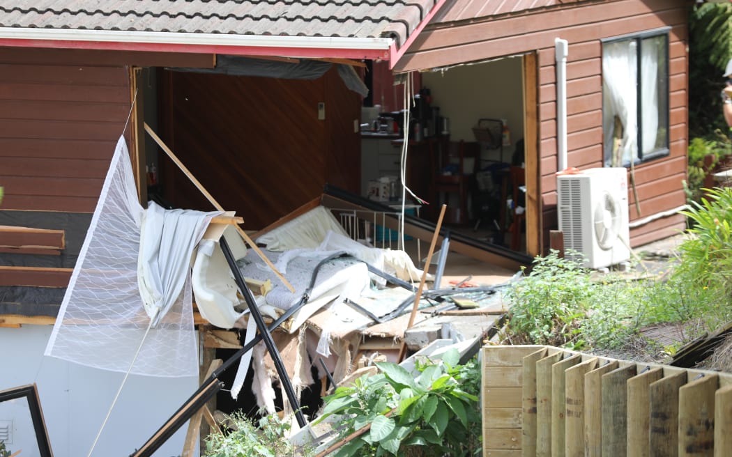 Two homes were damaged after a car left Don Buck Road and drove down a bank, through the lounge of one property and ended up in the bedroom of a neighbouring one.