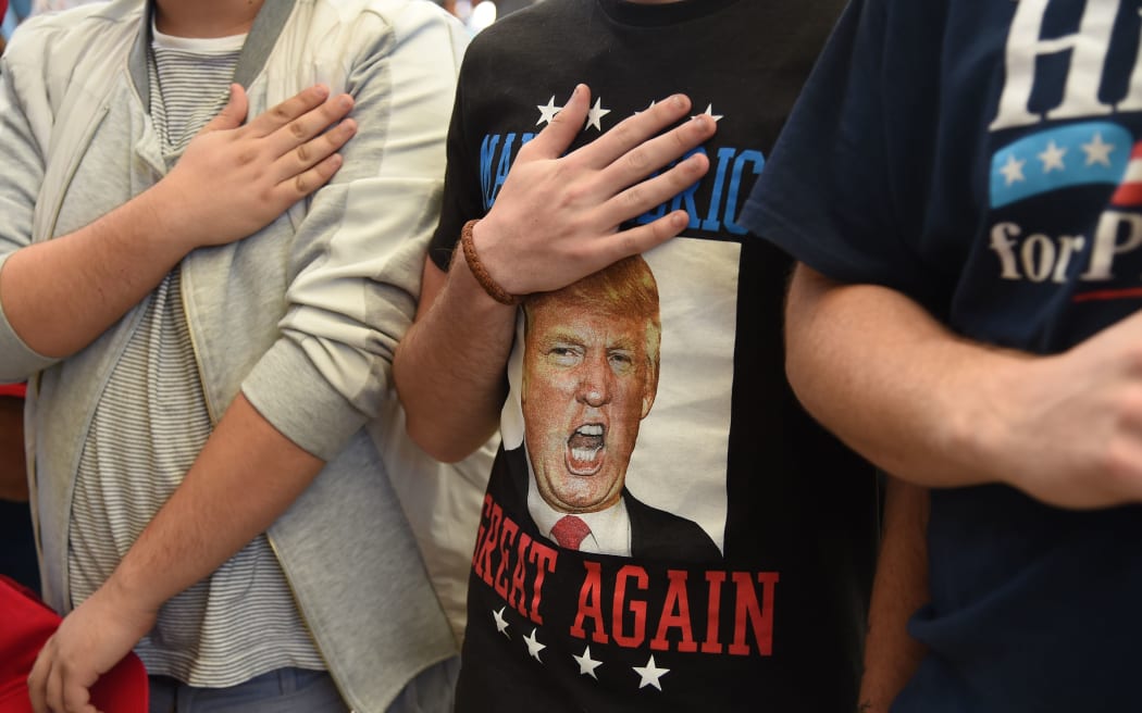 Supporters hold their hands over their hearts as they say the pledge of allegiance at a campaign rally by Republican presidential candidate Donald Trump, at the Henderson Pavilion, October 5, 2016 in Henderson, Nevada.