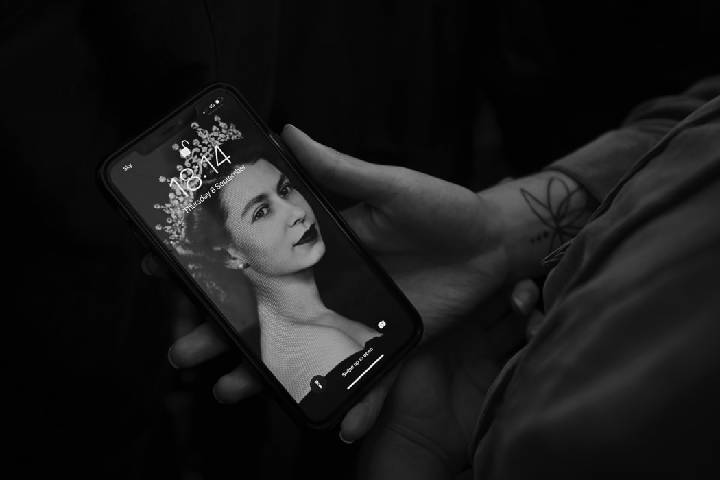 A person holds their phone with a screensaver of Queen Elizabeth II who died on September 9, 2022 in London, England.