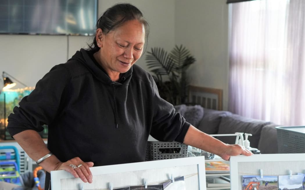 Pearl Poki with the pinboards holding pictures of her home being built and delivered