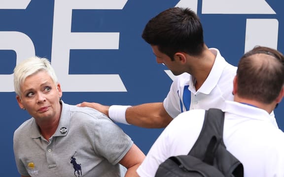 NEW YORK, NEW YORK - SEPTEMBER 06: Novak Djokovic of Serbia tends to a line judge who was hit with the ball during his Men's Singles fourth round match against Pablo Carreno Busta of Spain