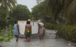 Tuvalu - locals moving a fridge following flooding