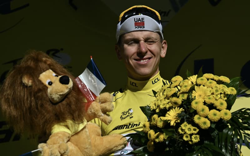 UAE Team Emirates-XRG’s Tadej Pogacar celebrates on the podium with the overall leader’s yellow jersey after the 10th stage of the 113th Tour de France on July 14, 2026. (Photo by Jeff PACHOUD / AFP)