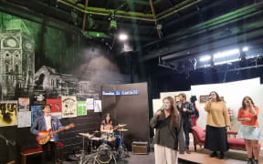 Musical director and guitarist Sam Miekle (far left) rehearses with the band and Aimee Freeman (centre) who plays Feste.