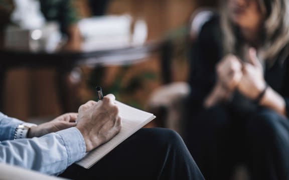 Psychiatry. Psychiatrist with unrecognizable patient, talking, taking notes. (Photo by MICROGEN IMAGES/SCIENCE PHOTO LI / SMD / Science Photo Library via AFP)